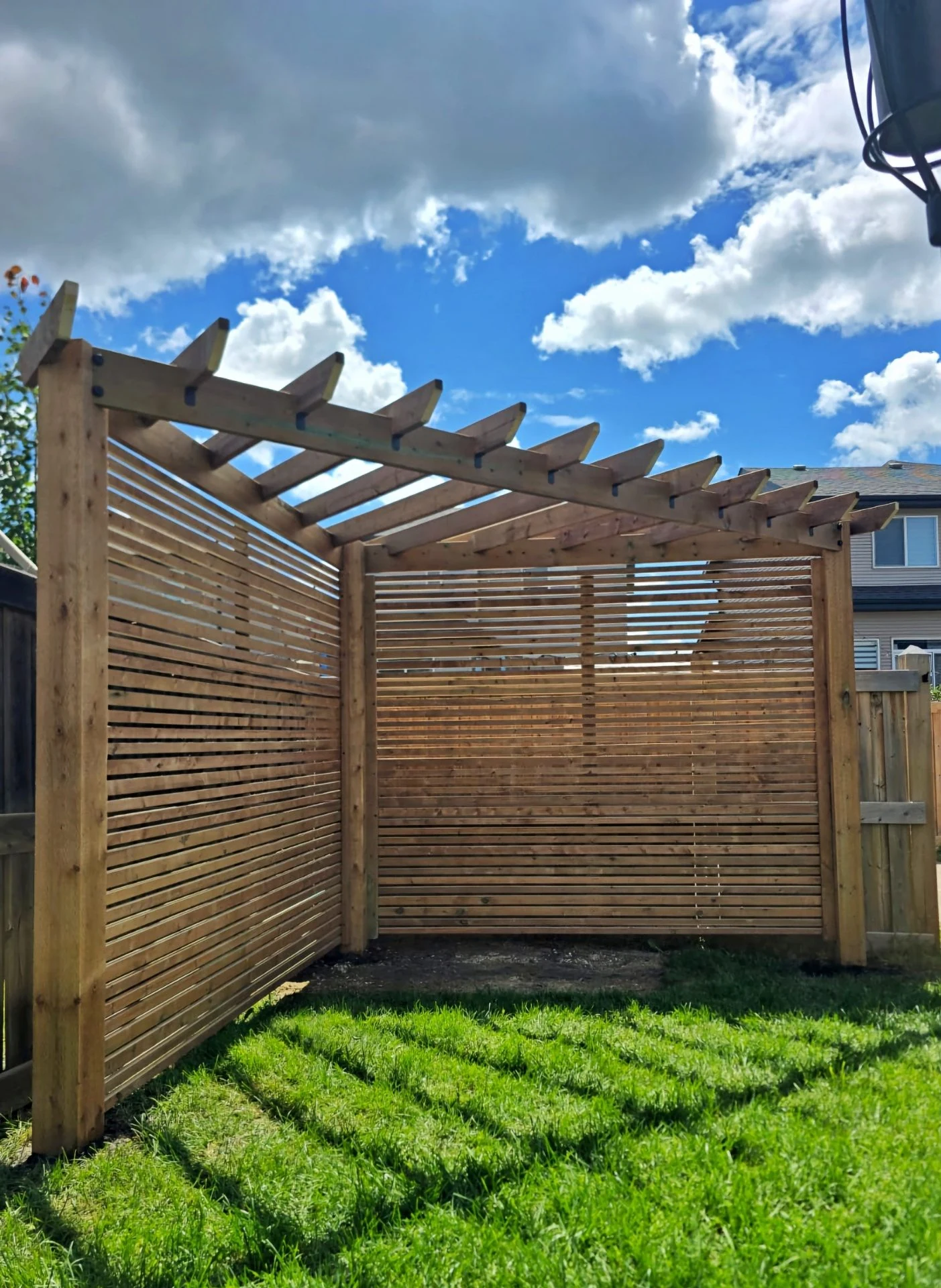 Pressure-treated pergola with horizontal slat privacy walls